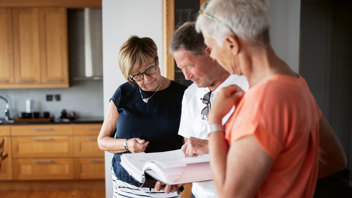 Karin Ek Hedle, Lucas Jönsson och Eva Kruse kikar igenom de papper som varje nyinflyttad får som introduktion till föreningen under det välkomnande som Brf Glasbruket alltid gör. Foto: Jenny Leyman