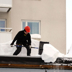 Bild man som skottar snö från tak