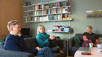 Grannarna Martin Wohlin, Ylva Liljeholm och Katja Jahn värmer sig framför brasan i föreningens gemensamma allrum. Foto: Andreas Renlund