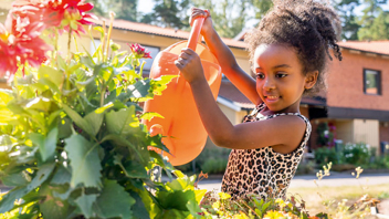 Bild Dina, 6, bor i Brf Dirigenten och tycker att det är roligt att hjälpa till och pyssla om blommorna. Foto: Magnus Glans